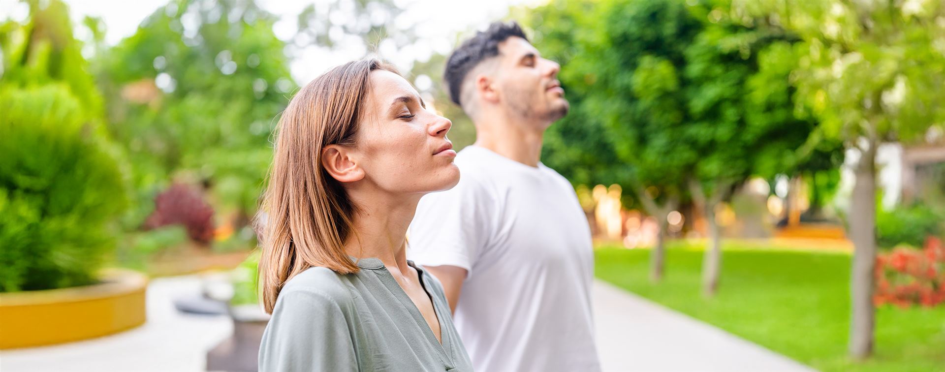 young-woman-man-with-closed-eyes-breathe-deep-park-practicing-yoga-meditation Kopie